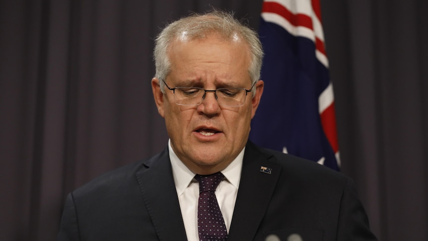 Scott Morrison looks down while holding a press conference