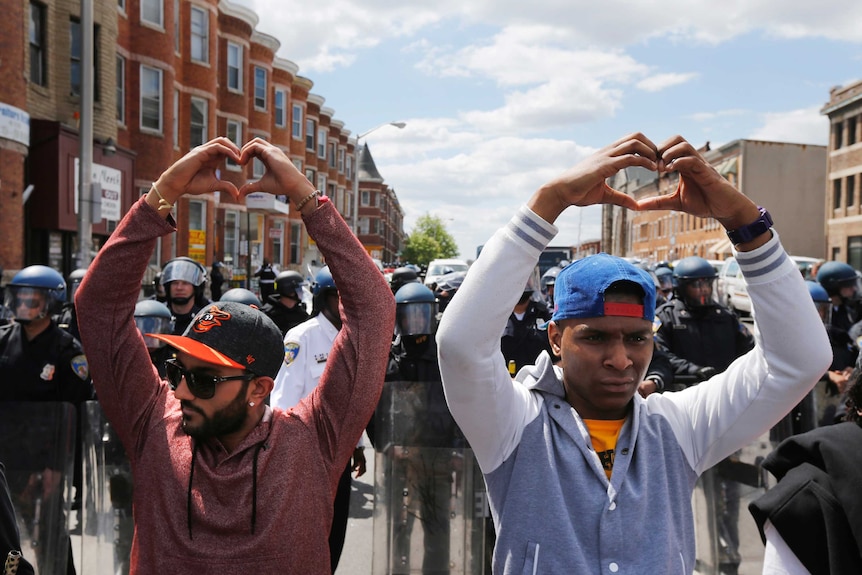 Baltimore locals make heart gestures following the funeral of Freddie Gray