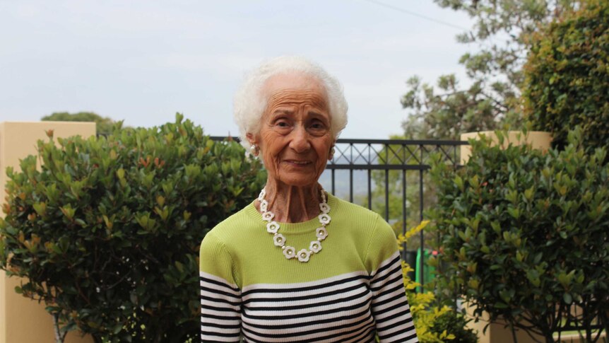 Evelyn Simmons stands in front of her garden in Coffs Harbour.