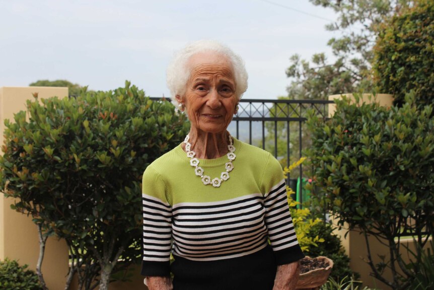 Evelyn Simmons stands in front of her garden in Coffs Harbour.