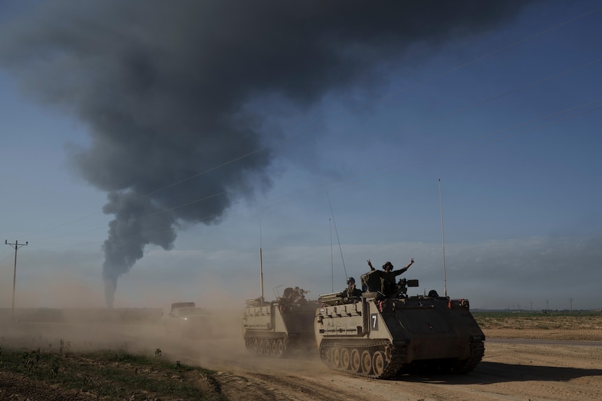 Israeli soldiers move on armored personnel carriers (APC) near the Israeli-Gaza border.
