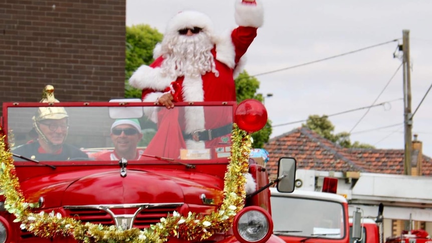 Santa arrives on an antique firetruck to deliver presents for disadvantaged children