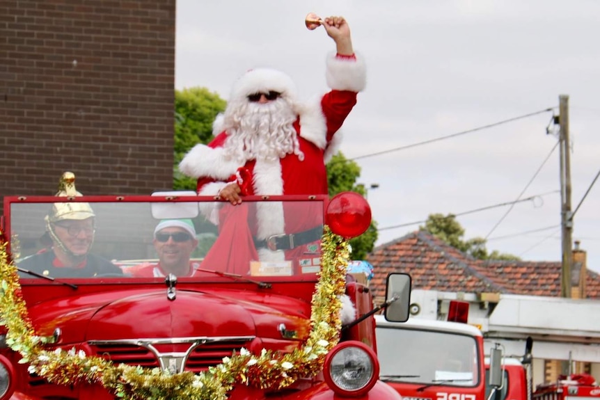 Santa arrives on an antique firetruck to deliver presents for disadvantaged children