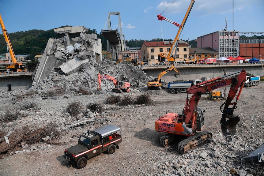 Workers use machinery to continue to clean up rubble from bridge collapse