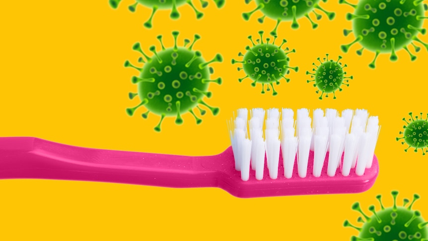 a pink toothbrush against a yellow background with green virus particles around it