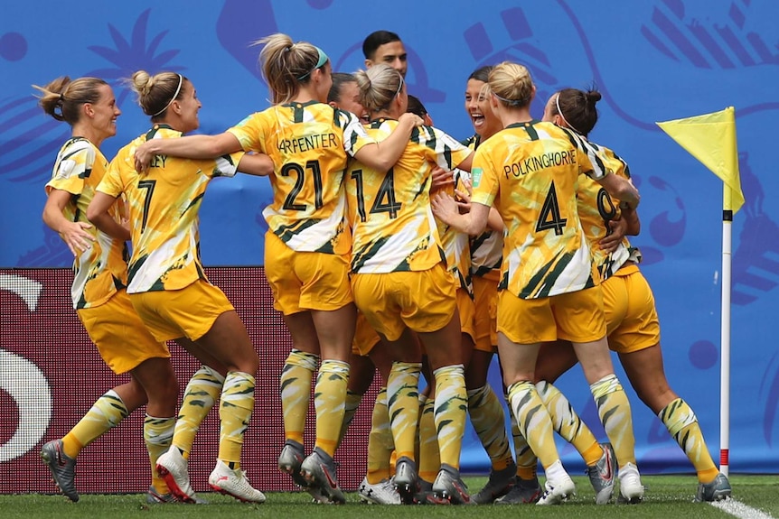 Players surround a smiling Sam Kerr.