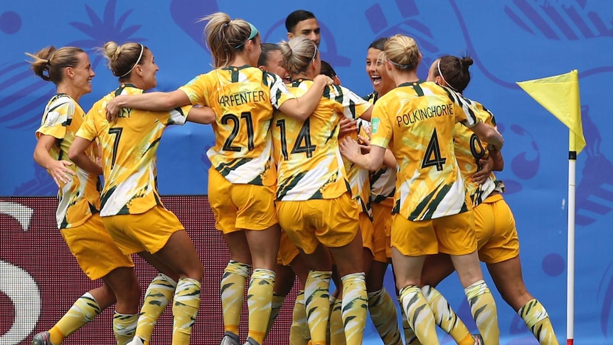 Players surround a smiling Sam Kerr.