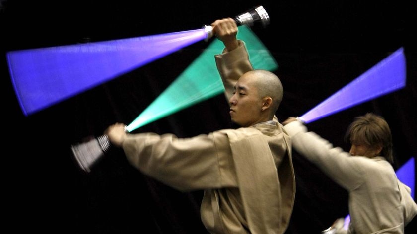 Participants dressed as Jedi Knight characters perform with their light sabres