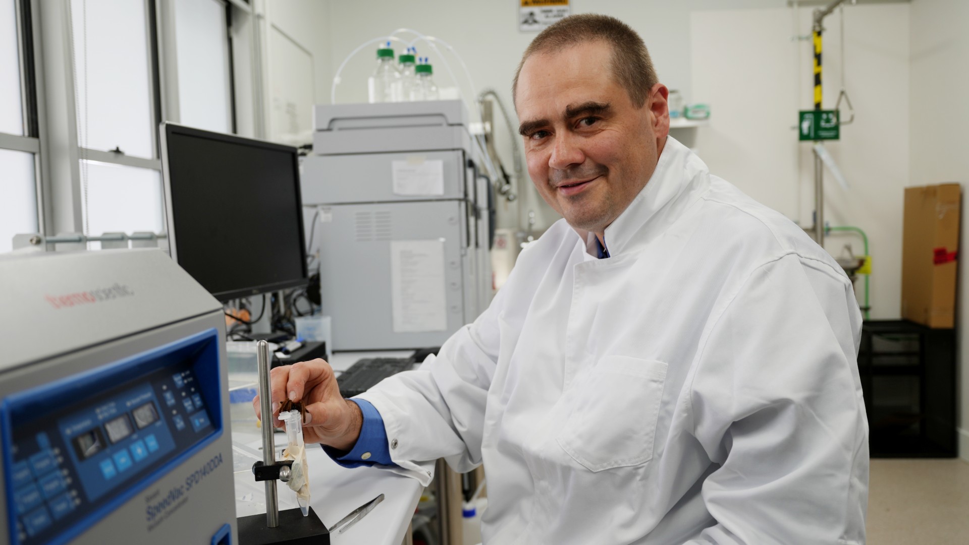 A smiling, middle-aged man in a laboratory.