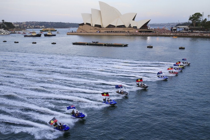 Jet skis fly the Australian and Aboriginal flag at Sydney Harbour.