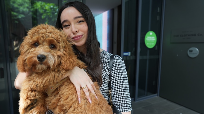 A woman holds a fluffy dog