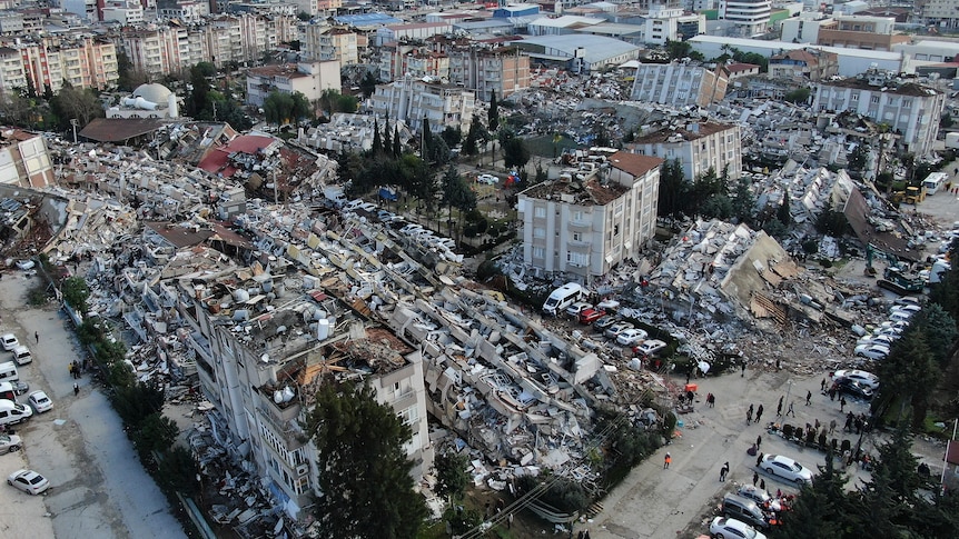 An aerial photo showing collapsed buildings and rubble in a city.