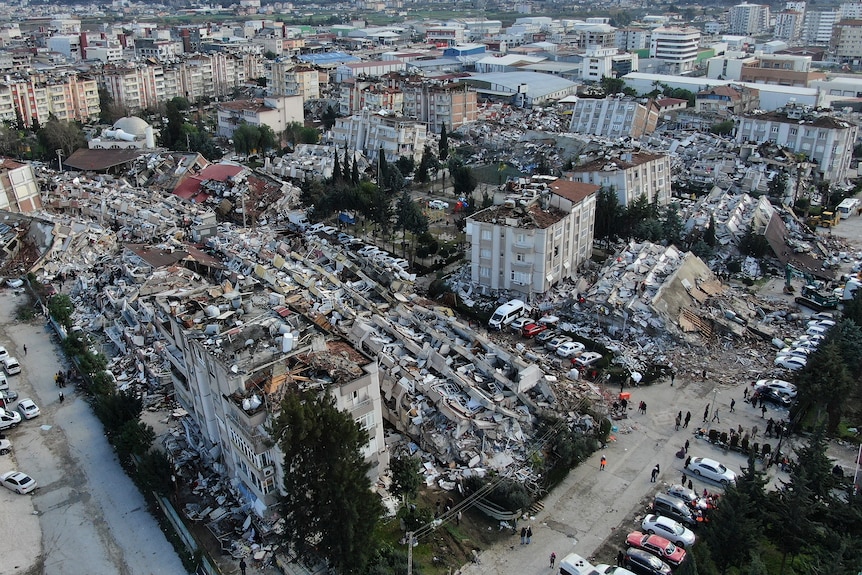 An aerial photo showing collapsed buildings and rubble in a city.