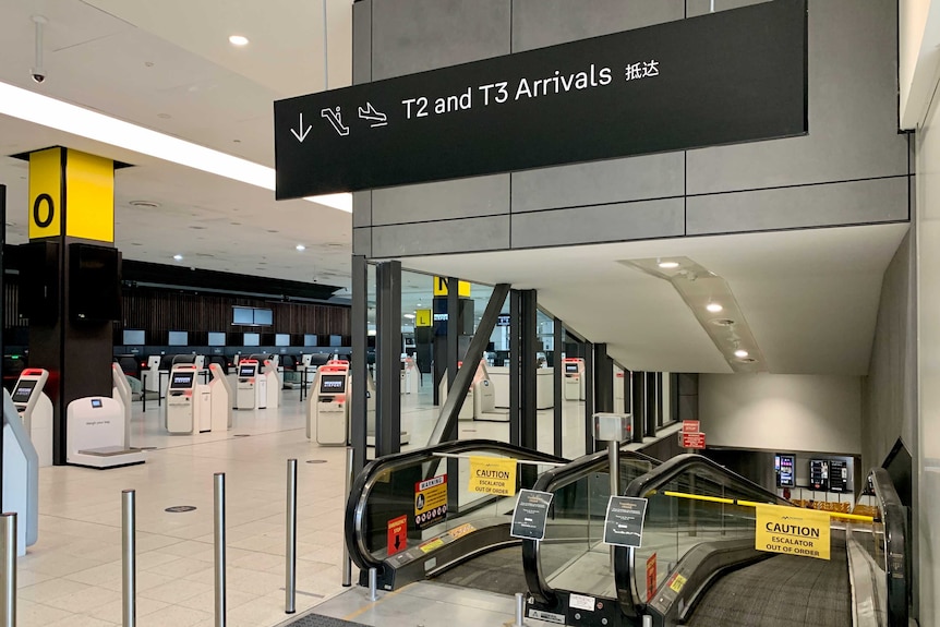 Closed escalators to an airport arrival hall.