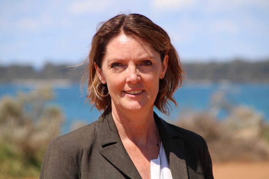 Close up of a woman wearing a business jacket standing in front of a wetland