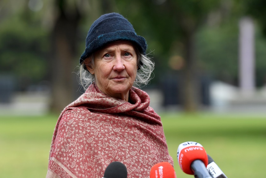 an elderly woman wearing a beanie looking