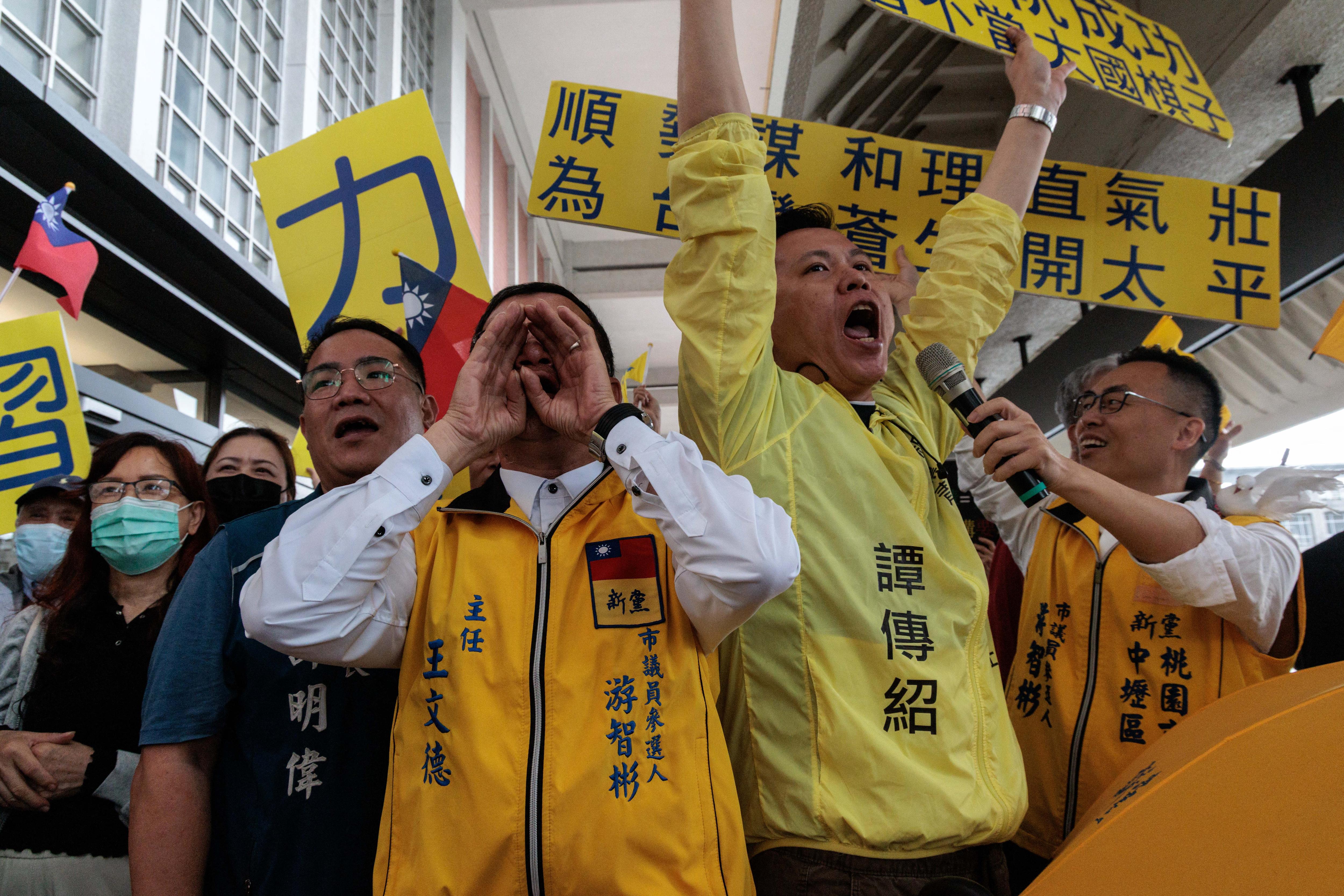 Supporters raising banners at an airport.