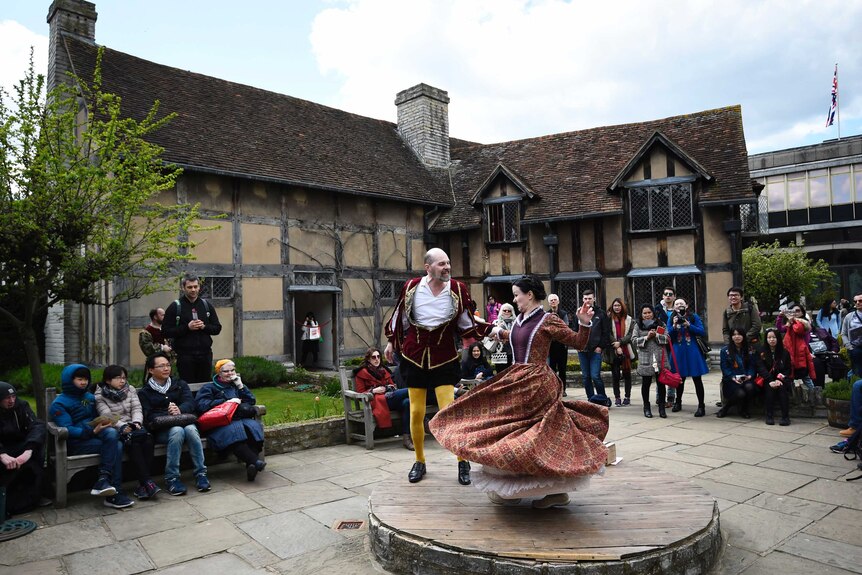 Tourists watch actors perform at the house where William Shakespeare was born.