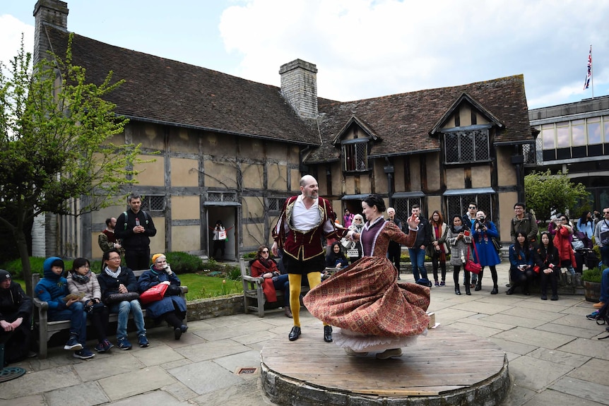 Tourists watch actors perform at the house where William Shakespeare was born.