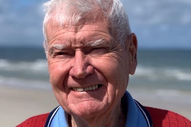 elderly man smiles at beach