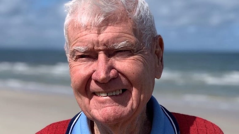 elderly man smiles at beach