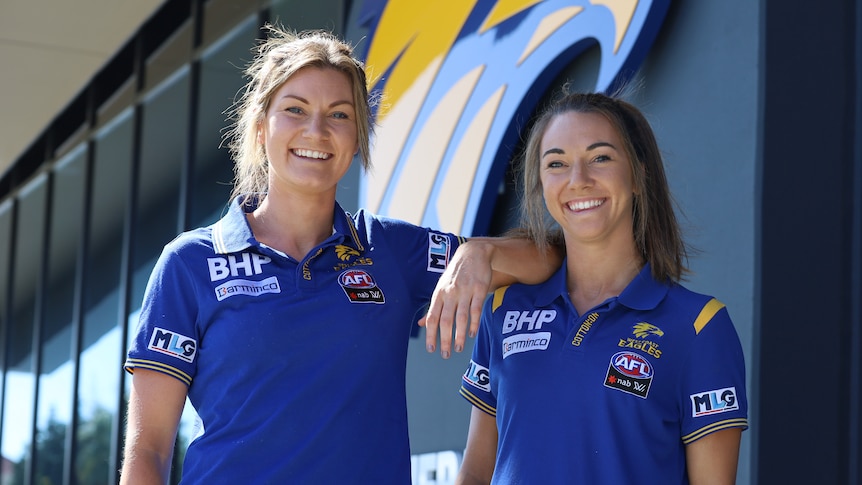 Grace and Niamh Kelly pose in West Coast Eagles clothing at the club's headquarters.