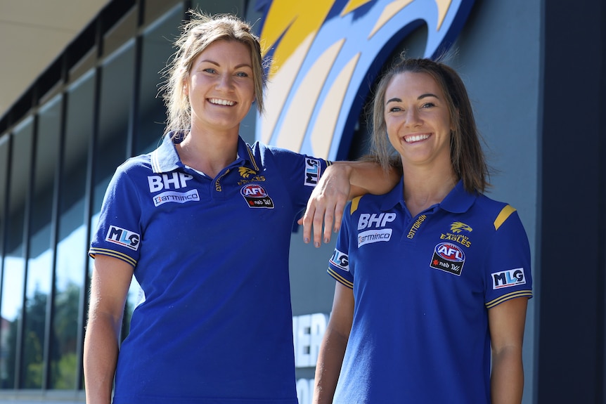 Grace and Niamh Kelly pose in West Coast Eagles clothing at the club's headquarters.