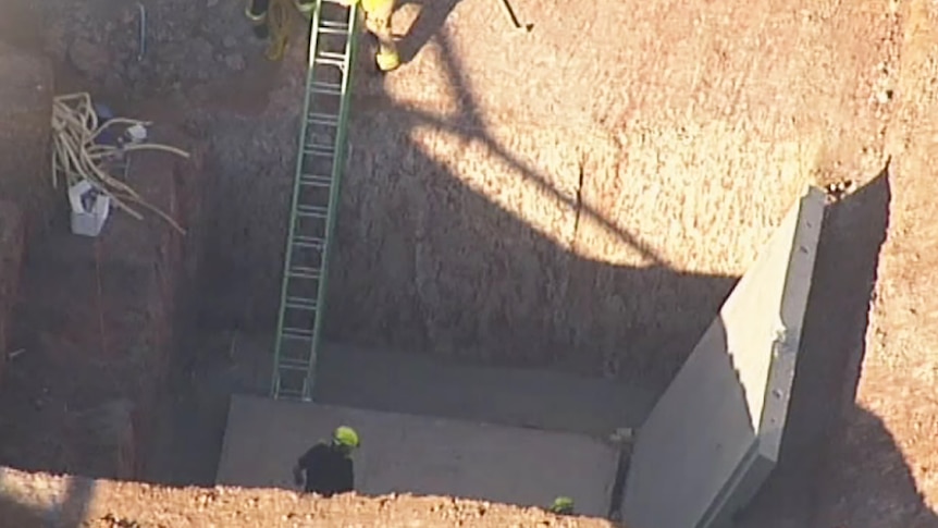 Workers at the scene where two construction workers were crushed to death