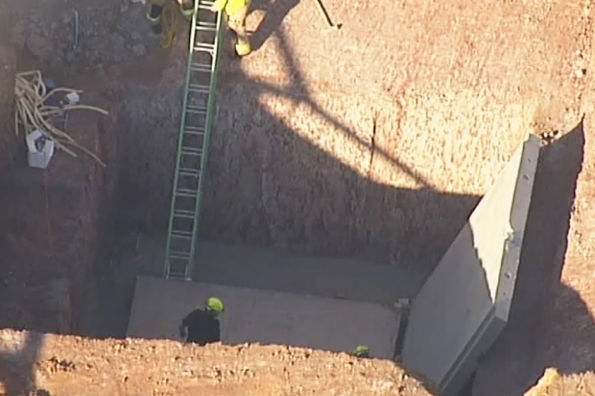Workers at the scene where two construction workers were crushed to death