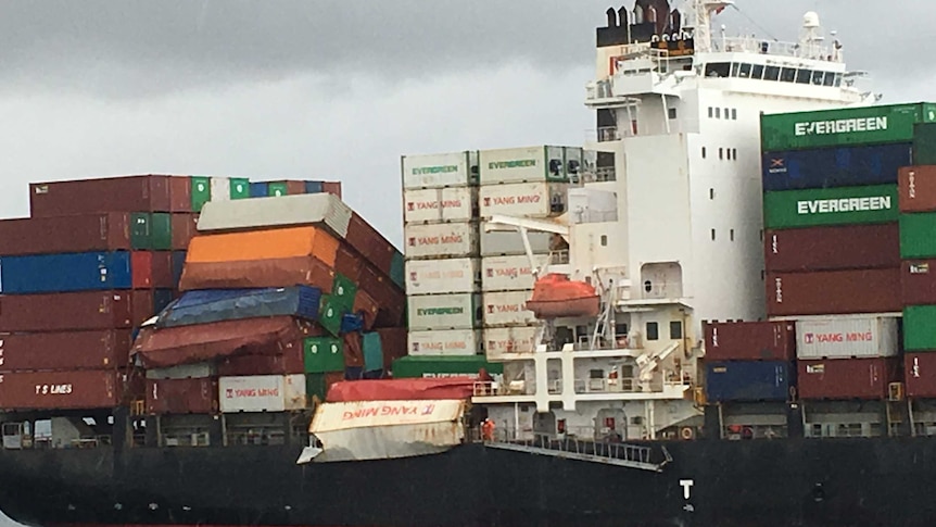 Damaged containers are visible on the deck of the YM Efficiency.