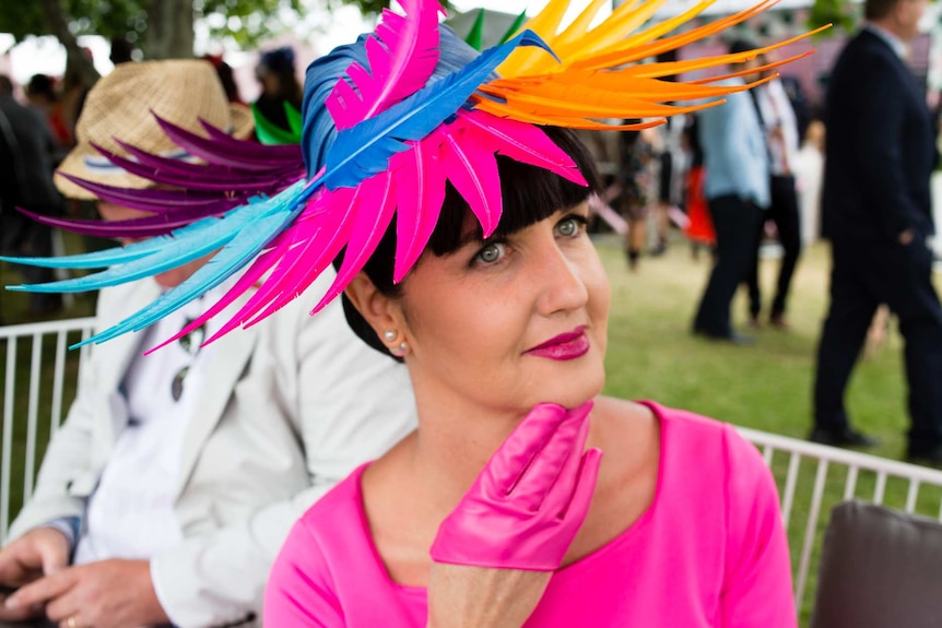 A woman wears a colourful feather hat at the Melbourne Cup at Flemington racecourse.