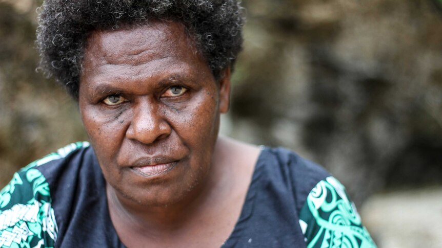 A woman from the island of Tanna in Vanuatu poses for a portrait with a serious expression on her face.