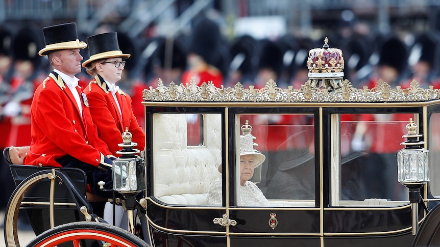 Queen Elizabeth II inside a royal carriage.