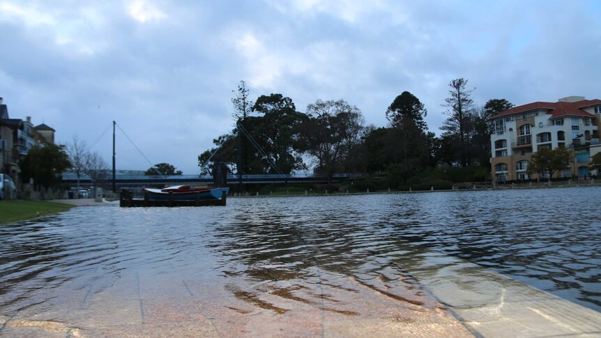 Water from Claisebrook cove floods the footpath in East Perth.
