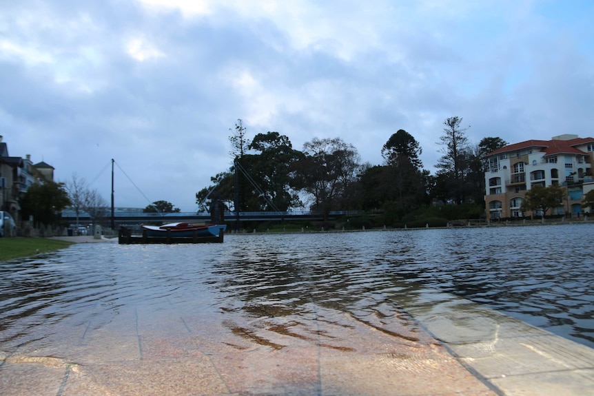 Water from Claisebrook cove floods the footpath in East Perth.