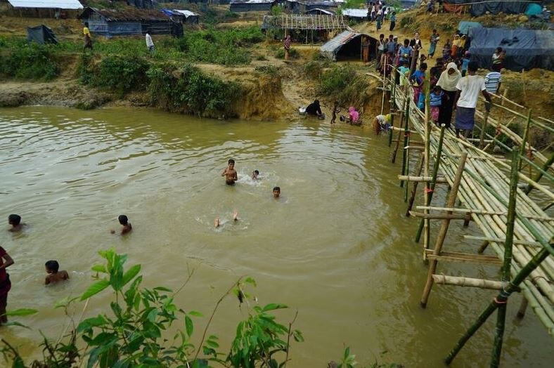 Children swim in a stream through camp in Rohingya refugee camp.