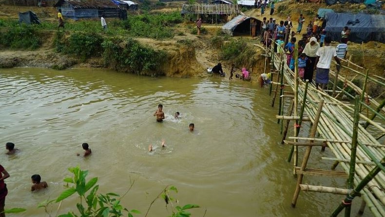 Children swim in a stream through camp in Rohingya refugee camp.