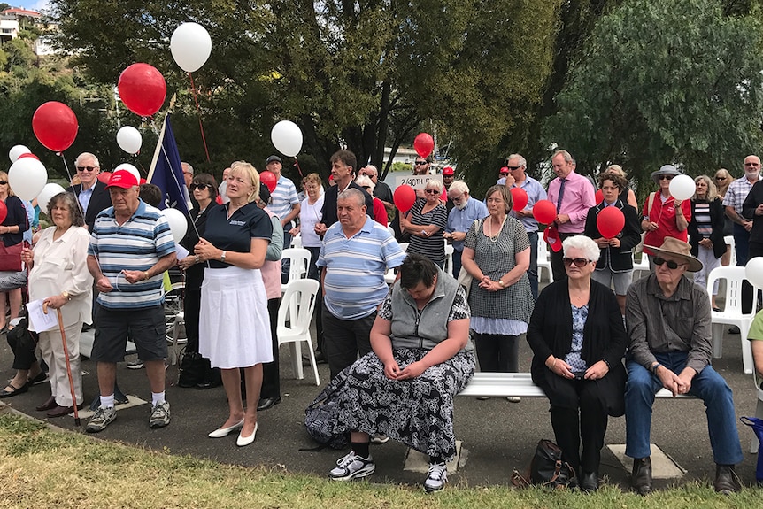 Friends and relatives of 2/40th battalion members hold balloons before releasing them in honour of the soldiers.