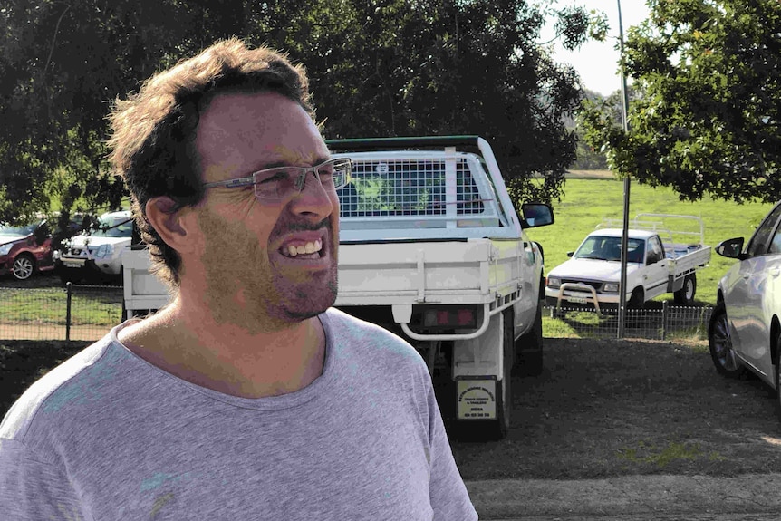 A middle aged man in a car park.