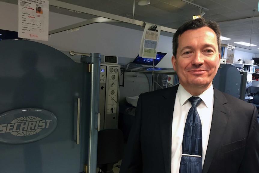 Dr David Cooper, Co-director of the Royal Hobart Hospital's Hyperbaric Unit, stands in front of equipment.