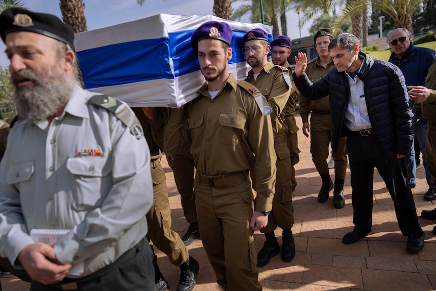 Father of Israeli soldier bids farewell as soldiers carry his son's flag-draped casket.