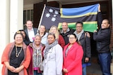 A group of South Sea Islanders stand in front of their flag at the Petersham Town Hall in inner west Sydney