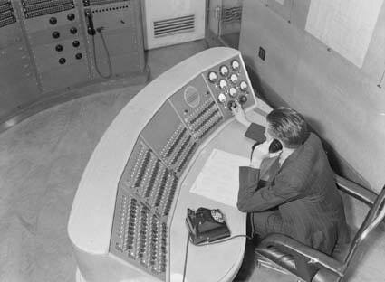 A black and white photo of a radio control room.