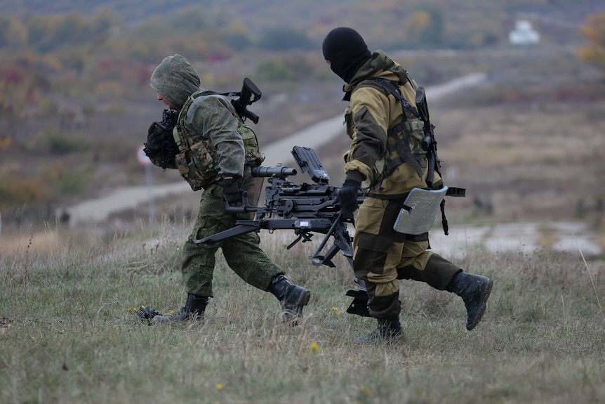 Russian recruits carry their weapon during a military training at a firing range.