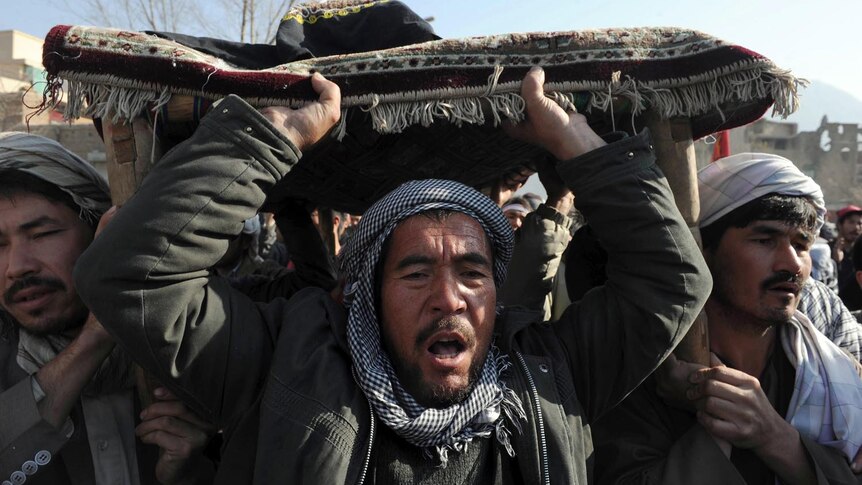 Anger and grief... Afghan men carry the coffin of a victim