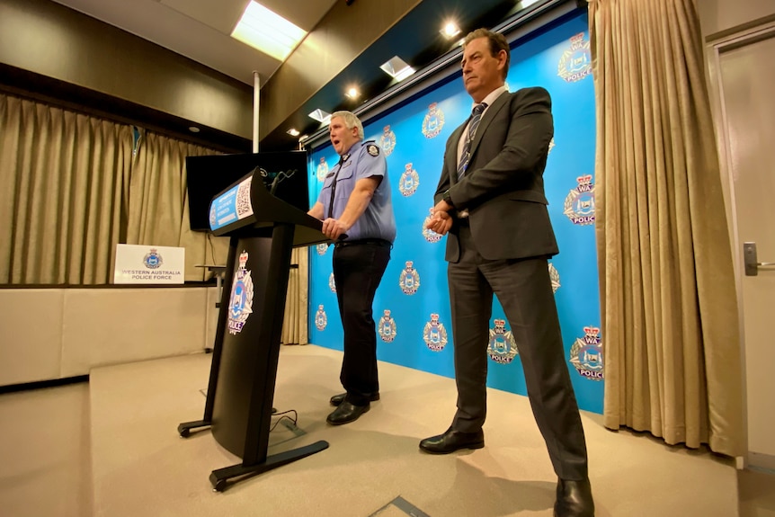 Two police officers stand at a podium