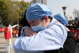 An emotional medical worker embraces another medical worker as they bid farewell in Wuhan.