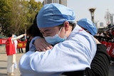 An emotional medical worker embraces another medical worker as they bid farewell in Wuhan.