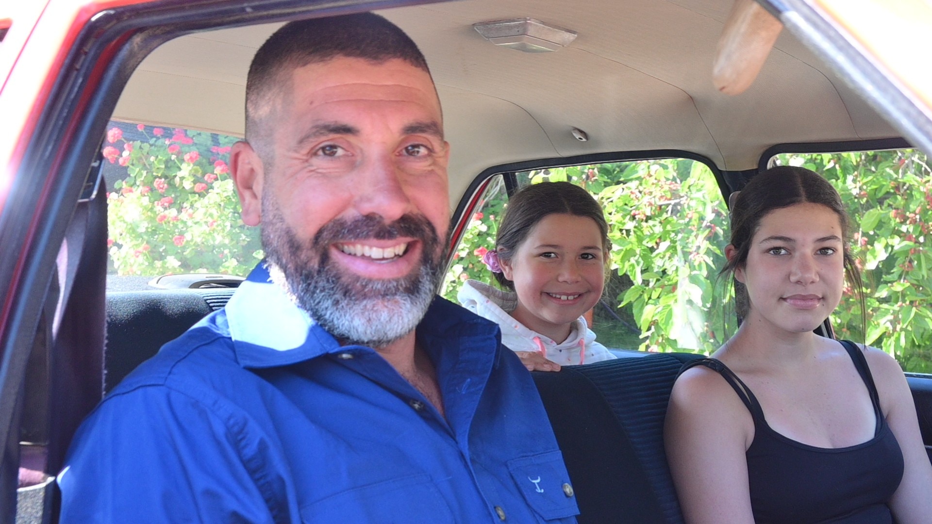 A man and two girls sitting in a car