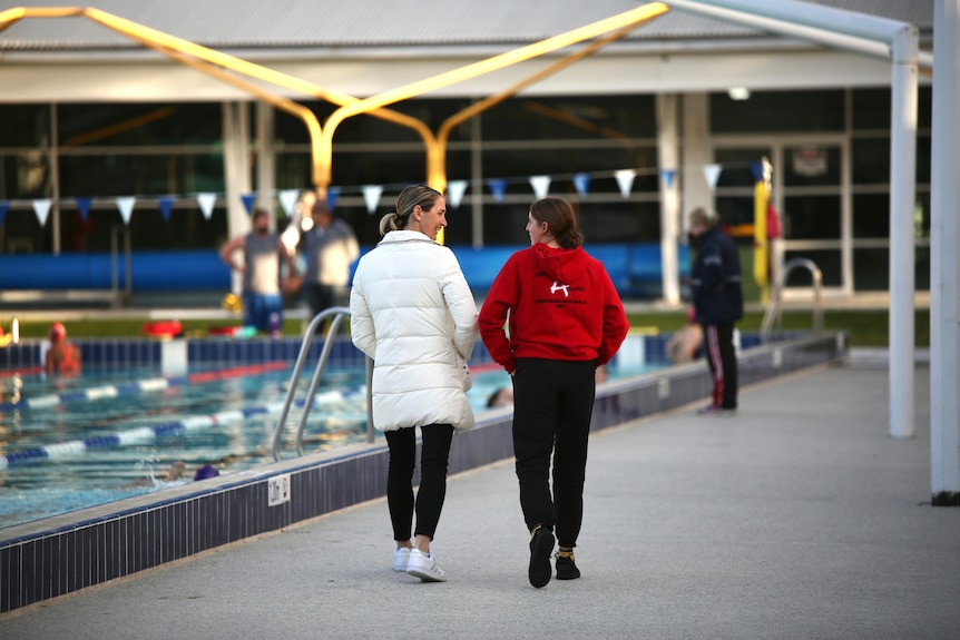 Sally Hunter walking by pool with Meg Hopkins